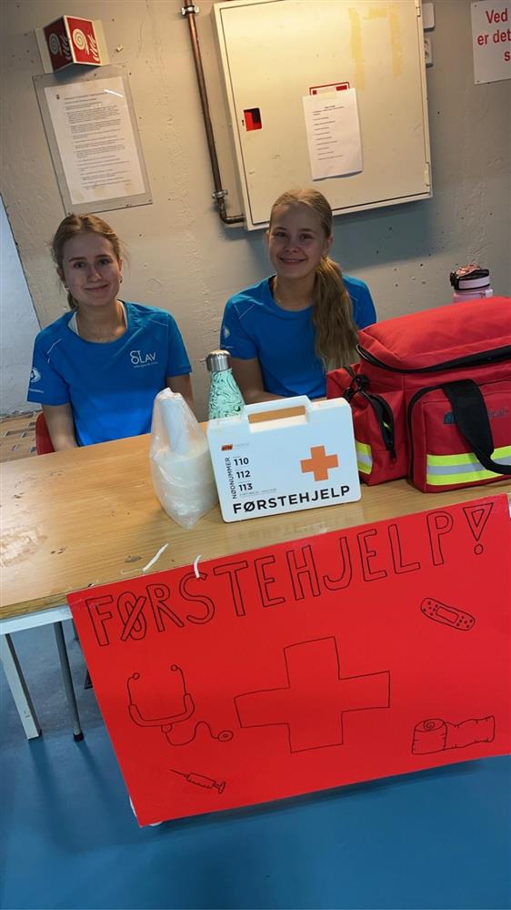 To jenter med førstehjelpsutstyr ved bord - Klikk for stort bilde