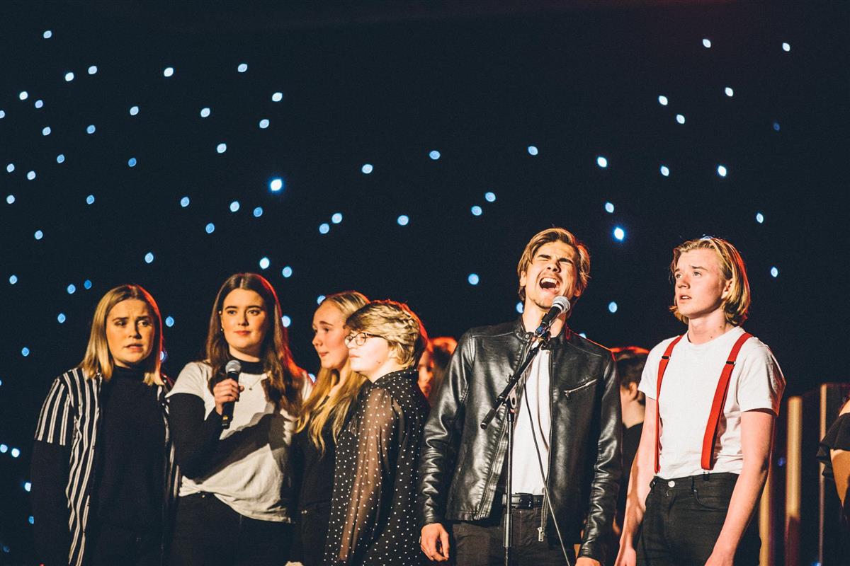 Fem elever på en scene som synger - Klikk for stort bilde