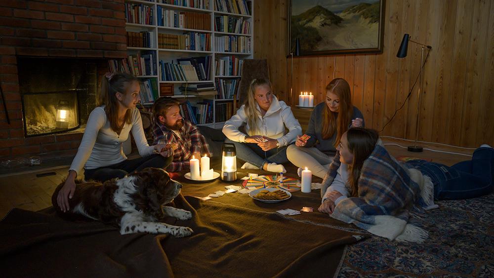 Jenter og gutter sitter på gulvet med lamper og pledd - Klikk for stort bilde