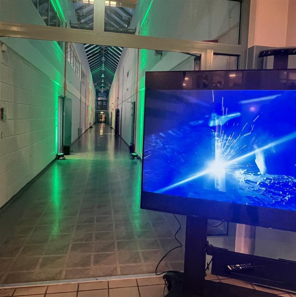 En korridor som er lyssatt med grønne og blå lys - Klikk for stort bilde